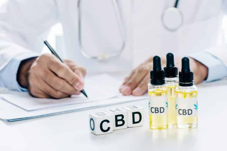 selective focus of cubes and cannabis oil with lettering CBD